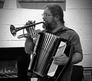 Robin holding an accordion and a cornet